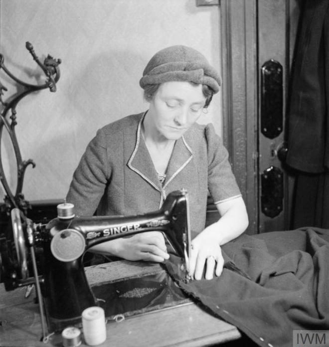 MEND AND MAKE DO: DRESSMAKING CLASSES IN LONDON, 1943 (D 12887) Mrs Bolton at work on a sewing machine during a Make Do and Mend class in the office of the Kennington branch of the Labour Party. She is making a coat for her 16 year old daughter on the sewing machine that she has bought to the class as part of the 'Equipment Pool', to which all members of the class contribute. Copyright: © IWM. Original Source: http://www.iwm.org.uk/collections/item/object/205125908